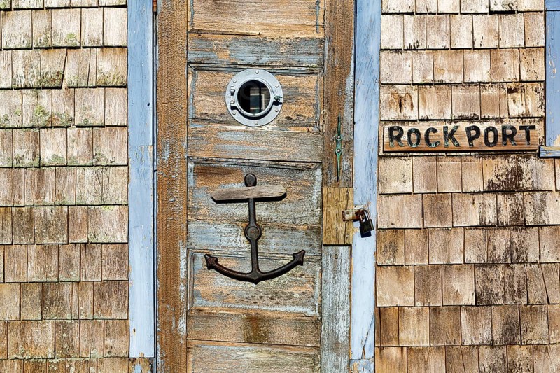 Maritime façade detail in harbor, door with anchor, typical wooden shingles and inscription, Bradley Wharf, Bearskin Neck, Rockport, Cape Ann, Massachussets, New England, USA