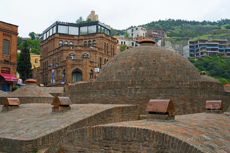 Historic brick buildings and urban baths in front of green hills, sulfur baths, Abanotubani spa district, old town, Tbilisi, Tbilisi, Georgia