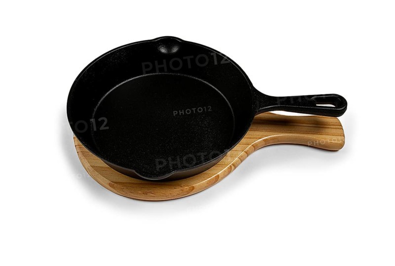 Portioned cast iron frying pan, on a wooden stand, new, on a white background, isolate