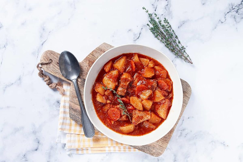 Meat goulash with potatoes and carrots, sweet peppers, in a saucepan, top view, traditional Hungarian soup, homemade, no people