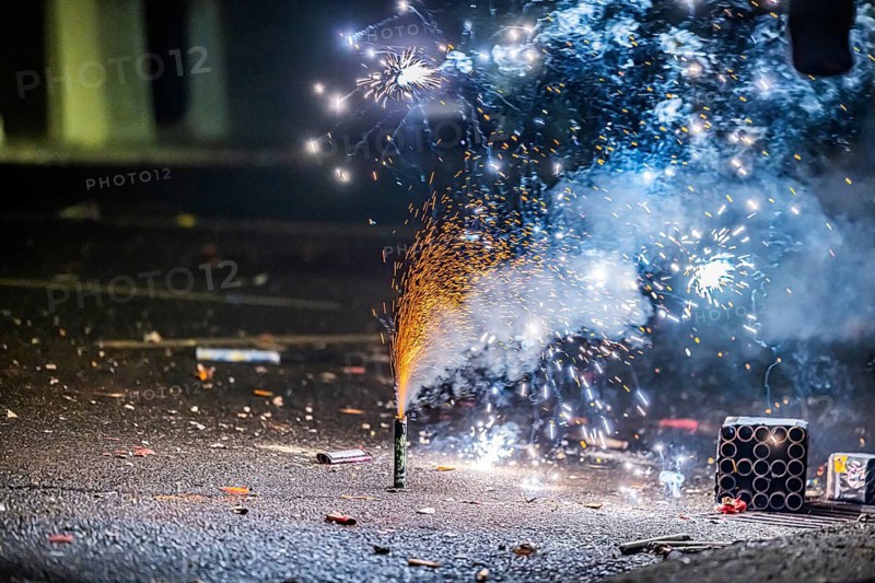 Burnt off fireworks are lying on the street, firecracker smoke produces smoke. New Year's night on a street in Stuttgart, Baden-Württemberg, Germany