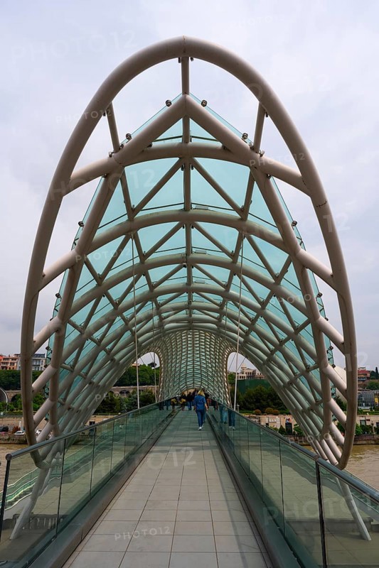 Modern, accessible bridge with glass roof and geometric pillars, Peace Bridge, Tbilisi, Kura River, Georgia