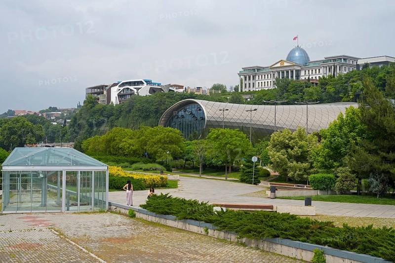 Glass-covered architecture in a park with green spaces, Rike Music Theatre and Exhibition Center, behind it State Palace for Ceremonies, Avlabari Residence or Presidential Palace, Tbilisi, Georgia