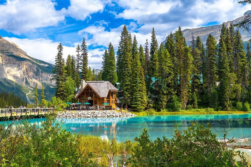 Emerald lake lodge with surrounding pine trees reflecting in the turquoise water of emerald lake in yoho national park, british columbia, canada, on a beautiful summer day