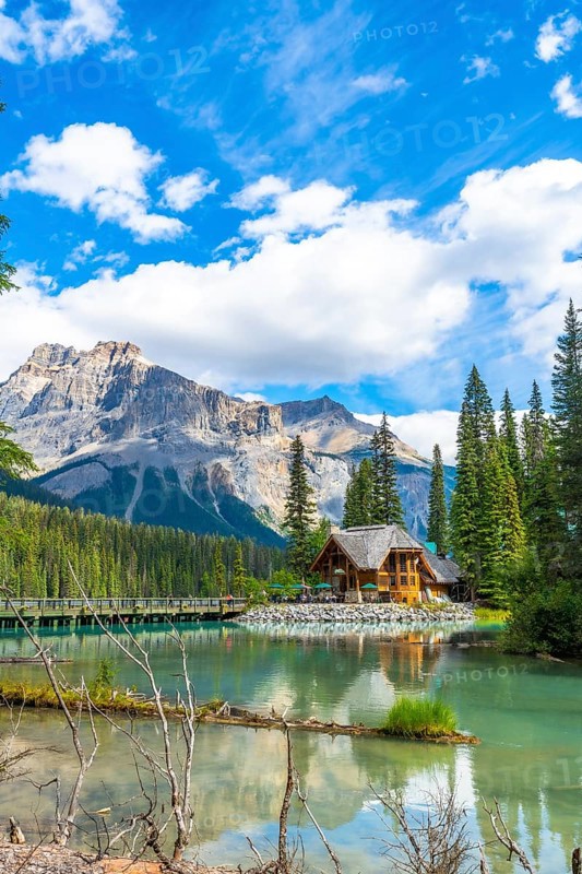 Emerald lake lodge reflecting on turquoise waters, framed by the canadian rockies and pine forest in yoho national park, british columbia, on a sunny summer day
