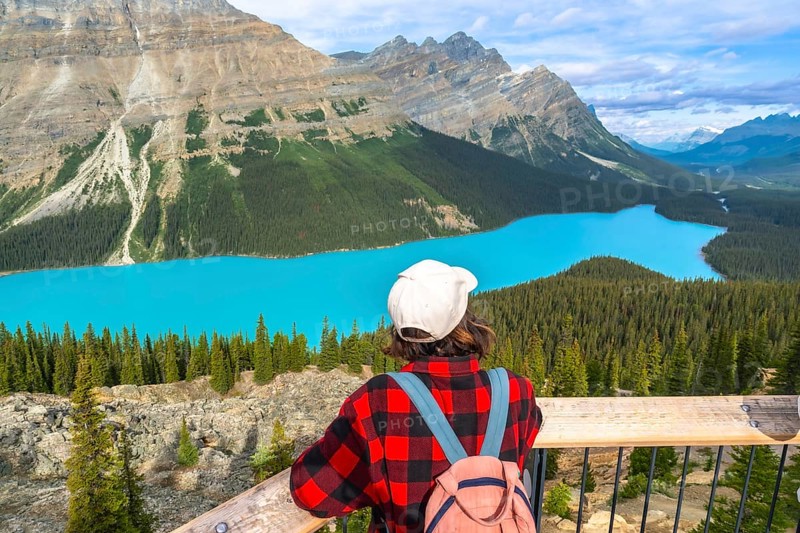 Tourist with a backpack enjoying breathtaking views of vibrant turquoise waters at peyto lake, surrounded by the majestic canadian rockies in banff national park