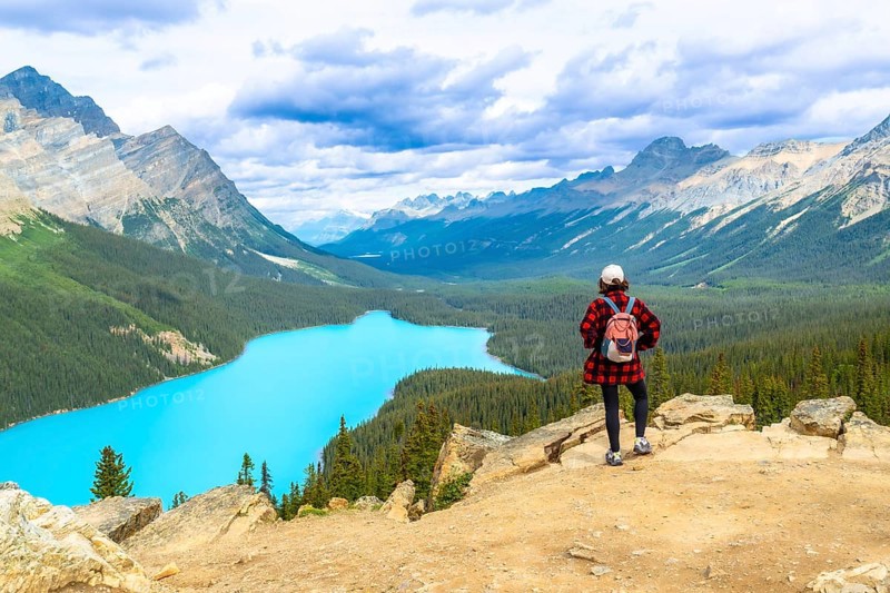 Hiker enjoying breathtaking view of turquoise peyto lake and surrounding rocky mountains in banff national park, alberta, a popular destination for outdoor enthusiasts