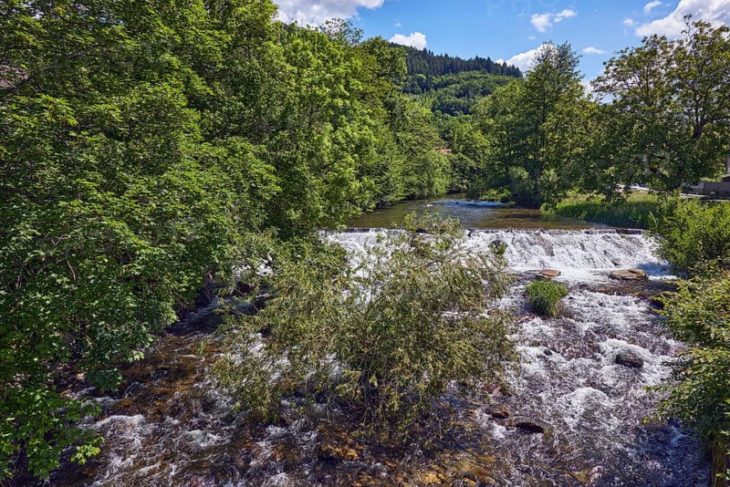 Wilde Gutach river, hills, hilly landscape, coniferous forest, trees, shrubs, wavy lively water surface, blue sky, cumulus clouds, Untertalstraße, Simonswald, Black Forest, Emmendingen district, Baden-Württemberg, Germany