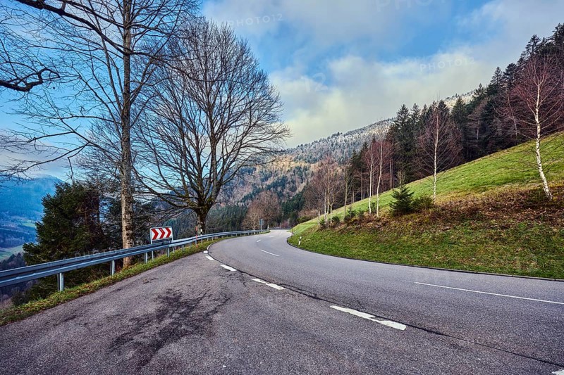 Simonswäldertal Dreitälerblick, hilly landscape, hill, road, center line, S-curve, coniferous forest, meadow, trees, bare winter trees, branches, haze, blue sky, cumulus clouds, country road L173, Simonswald, Black Forest, Emmendingen district, Baden-Württemberg, Germany