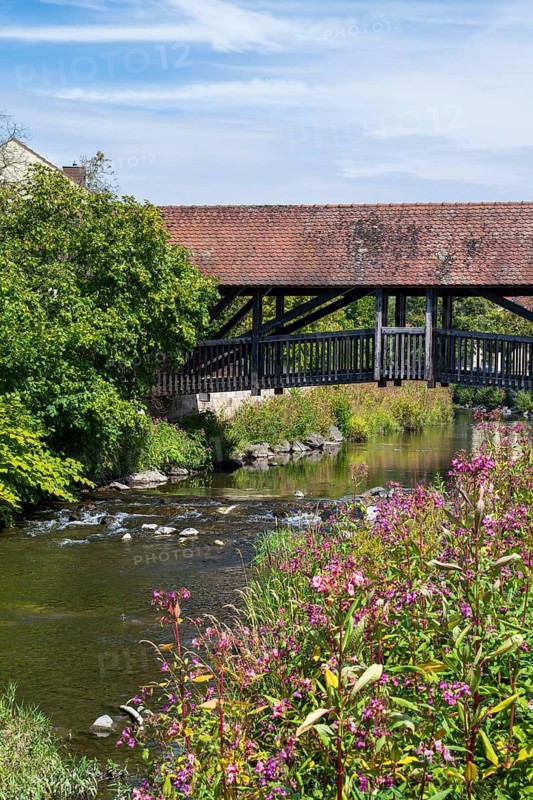 Covered footbridge over the Kronach river, hospital bridge, Blooming flowers on the shore, Kronach, Upper Franconia, Franconia, Bavaria, Germany
