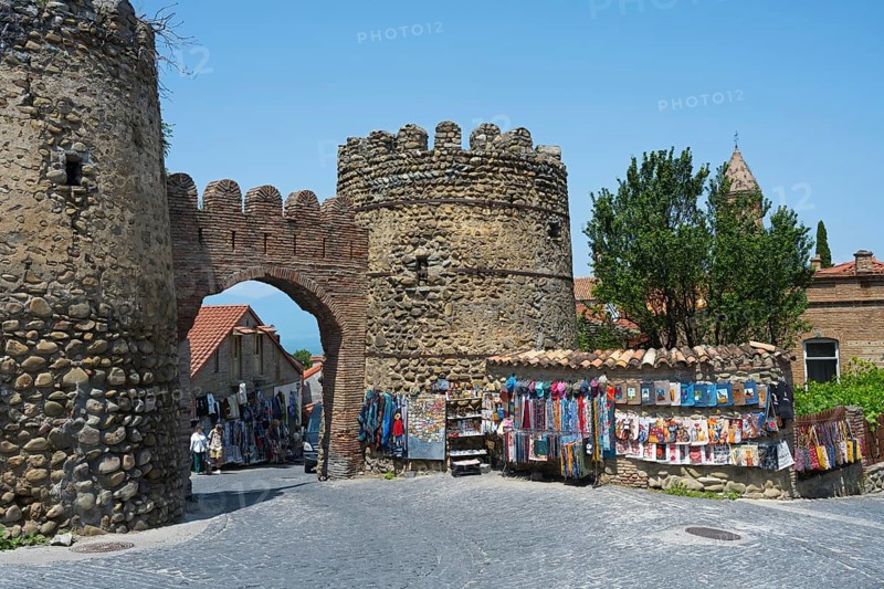 Stone gate with colorful souvenir stands and surroundings in a historic city, city gate, entrance to the old town, Sighnaghi, Signagi, Kakheti province, Greater Caucasus, Georgia, Western Asia