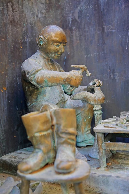 Shoemaker making shoes at Bonifatius Stirnberg's guild fountain 1983, modern art, bronze sculpture, city history, historical profession, shoemaker, hammering, processing, manufacturing, hammer, tool, guild fountain, Reutlingen, Swabian Jura, Baden-Württemberg, Germany