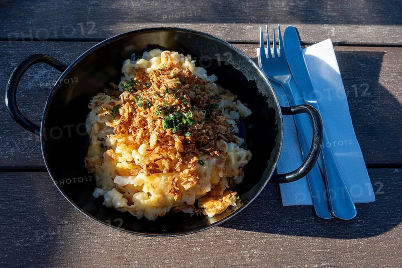 Typical food on an alpine pasture, a portion of cheese patzen or cheese socks in a cast pan, Bavaria, Germany