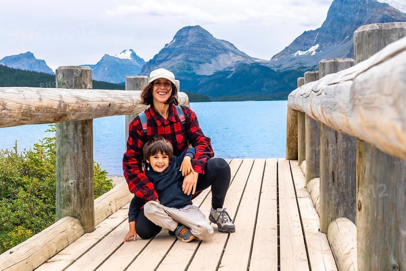 Tourists relishing the stunning scenery of bow lake in banff national park, alberta, canada, surrounded by majestic rocky mountains and enjoying a perfect summer day outdoors