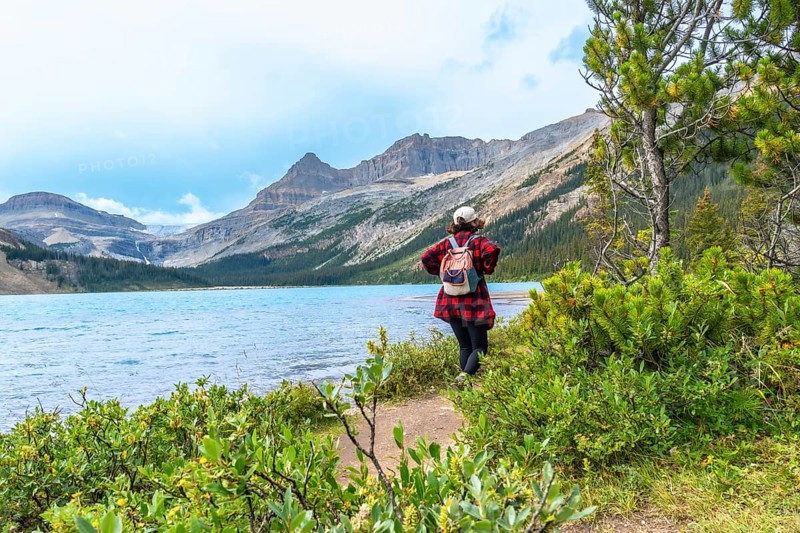 Female tourist enjoying the breathtaking view of bow lake and bow glacier in banff national park, embracing the tranquility of the canadian rockies in alberta, canada