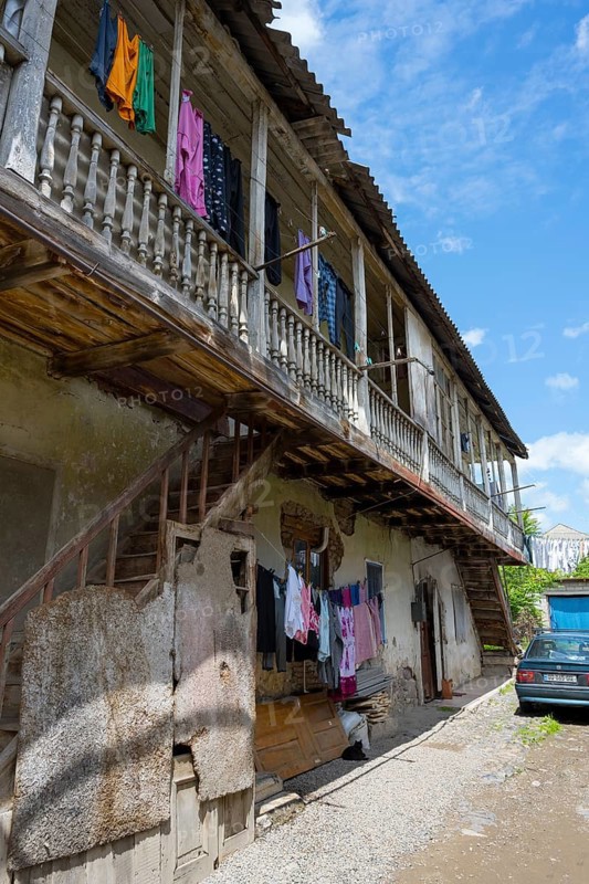 An old building with wooden balcony and clotheslines, next to it is an old car under a blue sky, traditional German house, Nikolaistraße 44, Bolnissi, Katharinenfeld, founded by Caucasian German settlers, Lower Kartli region, Kwemo Kartli, Georgia