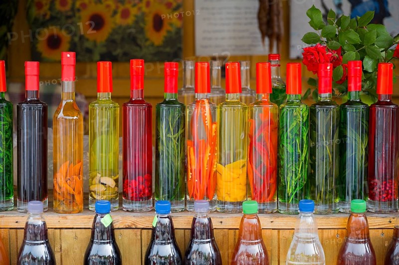 Strung bottles with colorful liquids on a wooden counter, chacha with colorful fruits, vegetables or spices, pomace brandy, grape distillate, Mtskheta, Mtskheta, Mtskheta, Mtskheta-Mtianeti region, Georgia