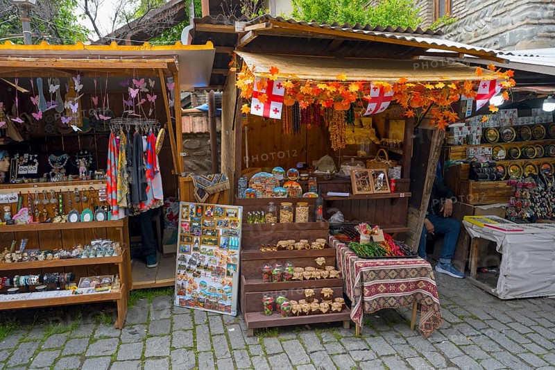 Market stalls with handmade souvenirs and decorations surrounded by flags and autumn leaves, Mtskheta, Mtskheta, Mtskheta-Mtianeti region, Georgia