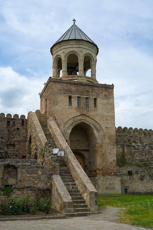 A bell tower with stone steps and fortress under a cloudy sky, Svetitskhoveli Cathedral, Svetitskhoveli, UNESCO World Heritage Site, Mtskheta, Mtskheta, Mtskheta-Mtianeti region, Georgia