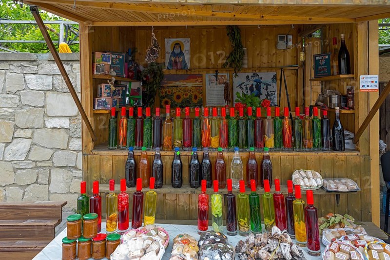 Market stall with various colorful bottles, food and souvenirs on a table, chacha with colorful fruits, vegetables or spices, pomace brandy, grape distillate, Mtskheta, Mtskheta, Mtskheta, Mtskheta-Mtianeti region, Georgia