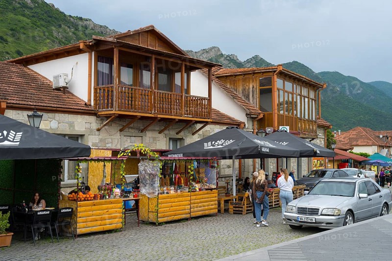 Cosy marketplace with cafes and shops framed by mountains under a cloudy sky, houses on Mtskheta Square, Mtskheta, Mtskheta, Mtskheta, Mtskheta-Mtianeti region, Georgia