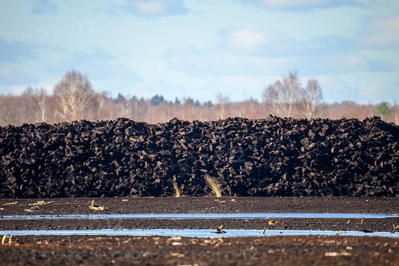 Layered peat sods Peating of a high-moor black peat in cloudy skies with earthy colors and natural texture, Diepholz Moor lowlands, Drebber, Lower Saxony, Germany