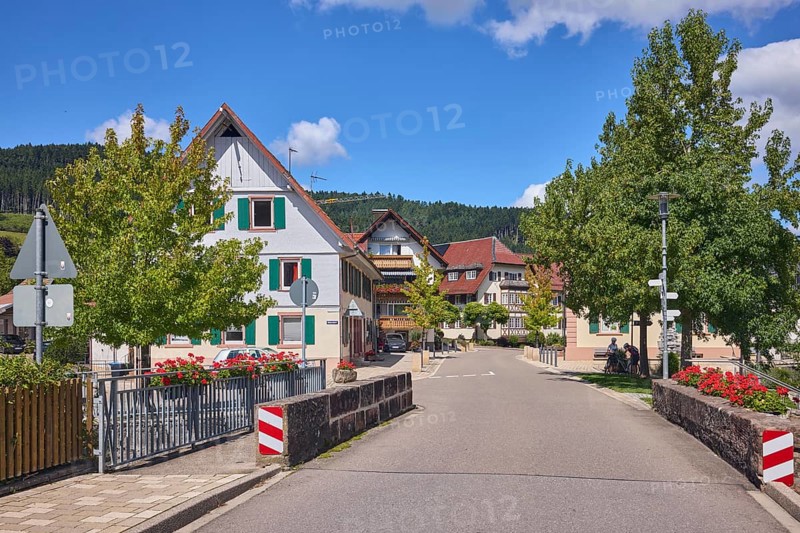 Car bridge and footbridge, sandstone, metal railings, flower boxes, general architecture, buildings, houses, lantern, trees, meadow, hill, coniferous forest, blue sky, cumulus clouds, intersection of main street with Unterdorf, Hofstetten, Black Forest, Ortenaukreis, Baden-Württemberg, Germany