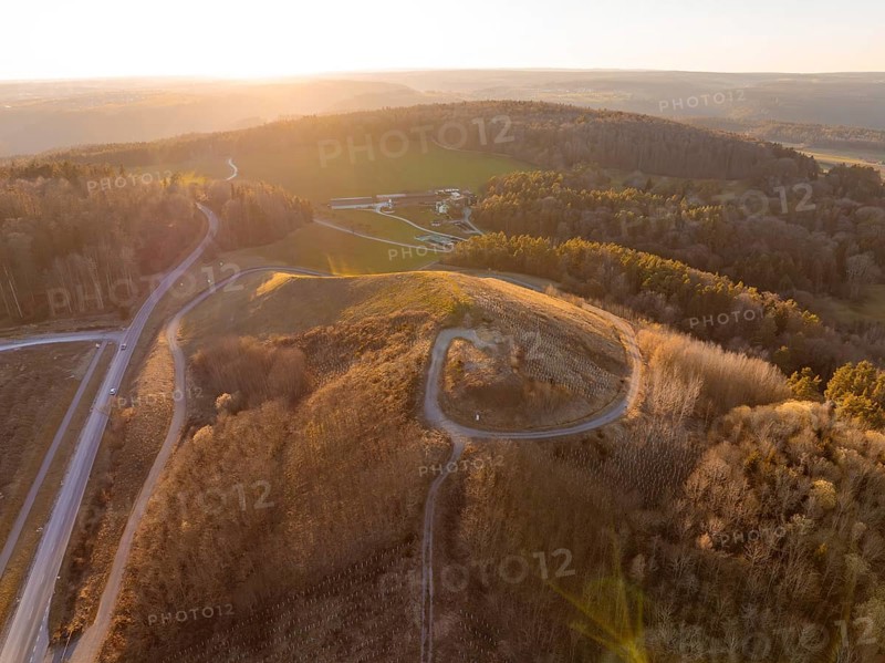 Landscape at sunset with hills and dense forest, future PV building on old deposit, Lindenrain industrial park, Calw, Germany