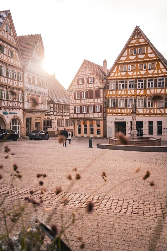 Historic old town with half-timbered houses and warm rays of sunshine on a quiet square, Herrenberg, Böblingen district, Germany