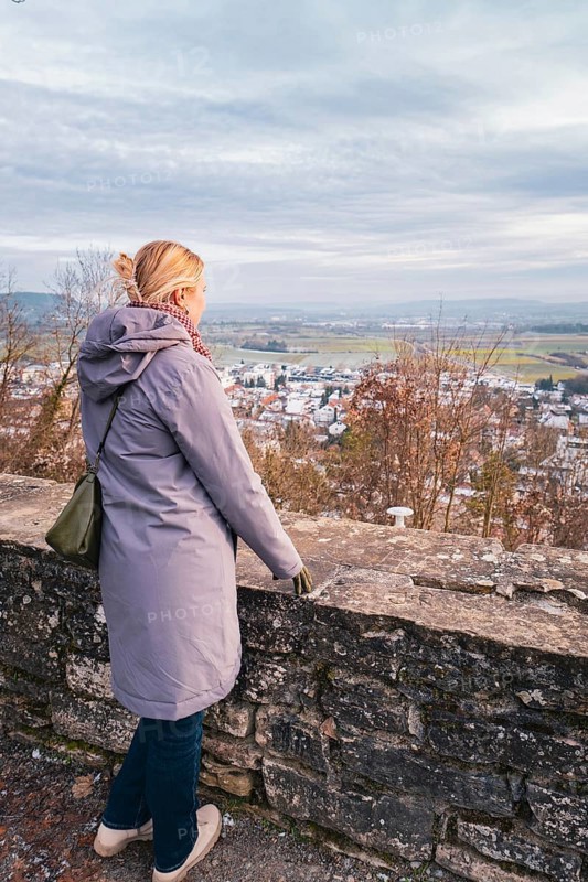 Woman in a coat looking out over a quiet winter landscape with a wide view, Herrenberg, Böblingen district, Germany
