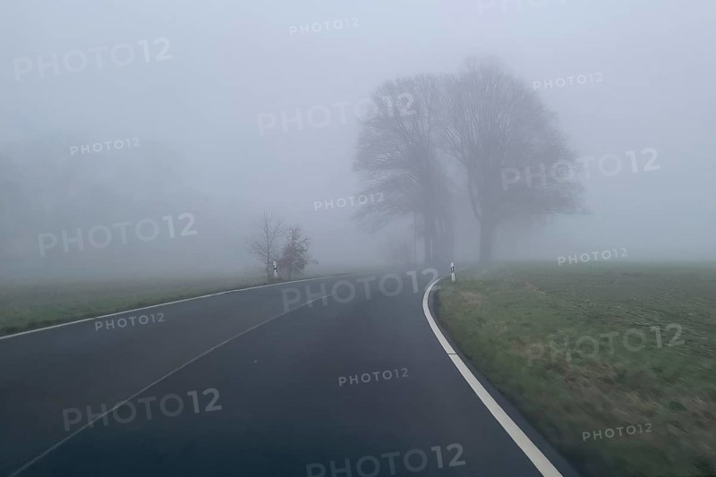 Driver's perspective view of foggy, foggy country road in thick fog in winter, Germany