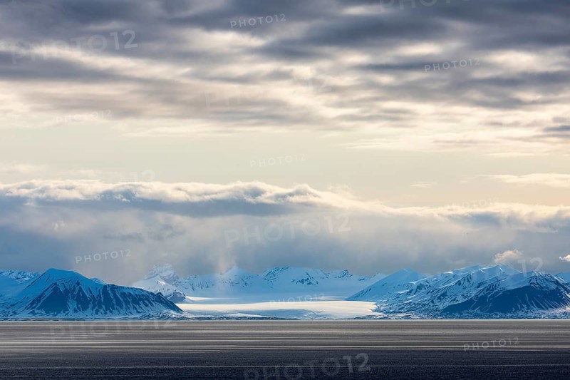 Glaciers between snow-capped mountains at sea, clouds, Longyearbyen, Spitsbergen, Svalbard