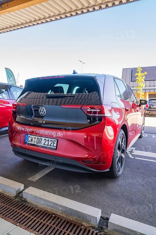 Red Volkswagen car sharing car in parking lot with urban atmosphere and modern design, ID3, Deer e-Carsharing, Germany