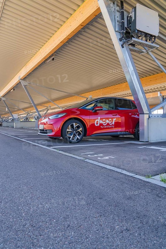 Red electric car parked under a modern roof in a parking lot, ID3, Deer e-Carsharing, Germany