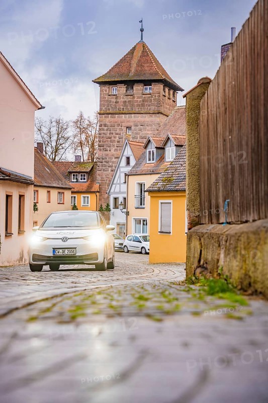 Scene in Altstadtgasse with cobblestones and a fortified tower, ID3, Deer E-Carsharing, Germany