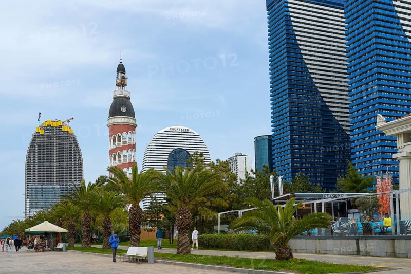 A mix of modern skyscrapers and a round tower offers a contrasting city view under cloudy sky, Batumi, Black Sea, Ajara region, Adjara, Autonomous Republic, Georgia