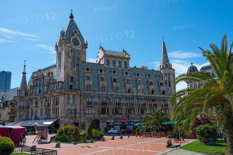 Historic building with towers and palm trees on an open square under a blue sky, Europe Square, Batumi, Black Sea, Ajara region, Adjara, Autonomous Republic, Georgia