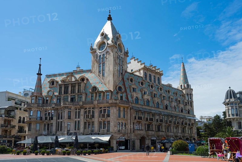 Large building with towers and roof gables in a sunny public square, Europe Square, Batumi, Black Sea, Ajara region, Adjara, Autonomous Republic, Georgia