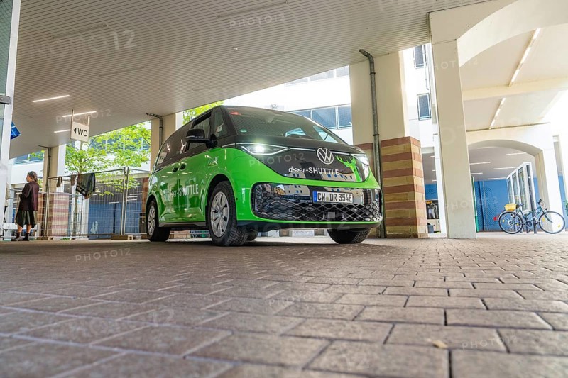 Green VW under roof in urban environment, Deer E-Mobility Shuttle Service, Calw, Germany