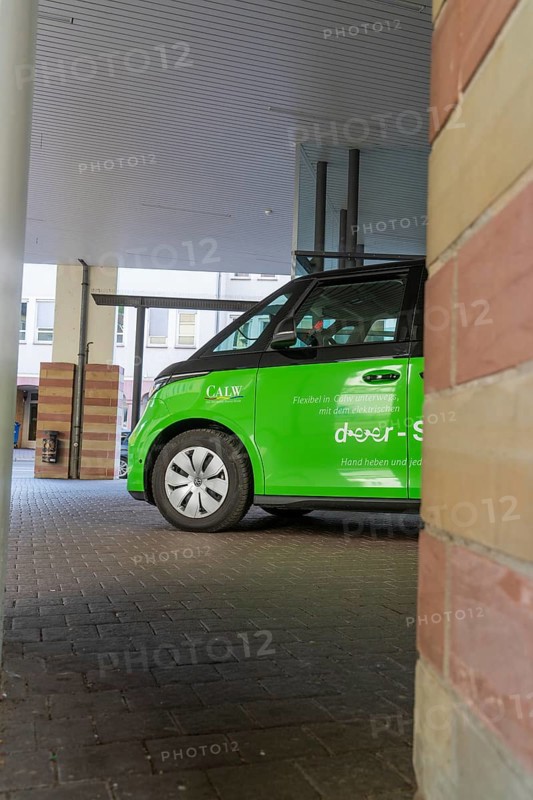 Green car in a covered area of a modern city, Deer E-Mobility Shuttle Service, Calw, Germany