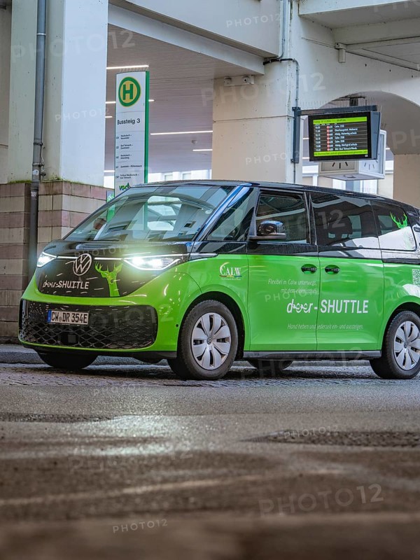 Green shuttle at a bus stop, equipped with digital display and urban design, Deer E-Mobility Shuttle service, Calw, Germany