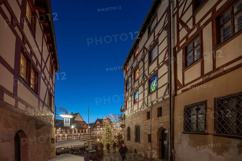 Historic half-timbered houses with a view of the Christmassy decorated Tiergärtnertorplatz in the evening lighting, on the right the Pilatus House with advent calendar, Ölberg, Nuremberg, Middle Franconia, Bavaria, Germany