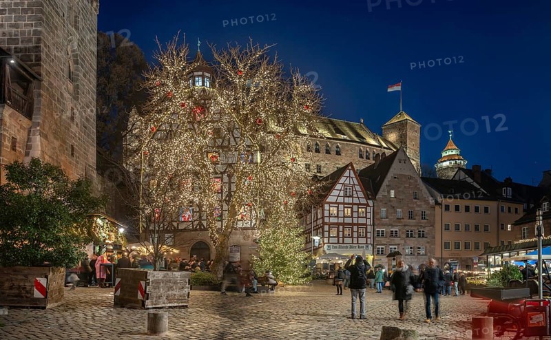 Christmassy illuminated square with the historic Pilate House with advent calendar, in the evening lighting, the Kaiserburg and Sinwell Tower in the back, Beim Tiergärtnertor, Nuremberg, Middle Franconia, Bavaria, Germany