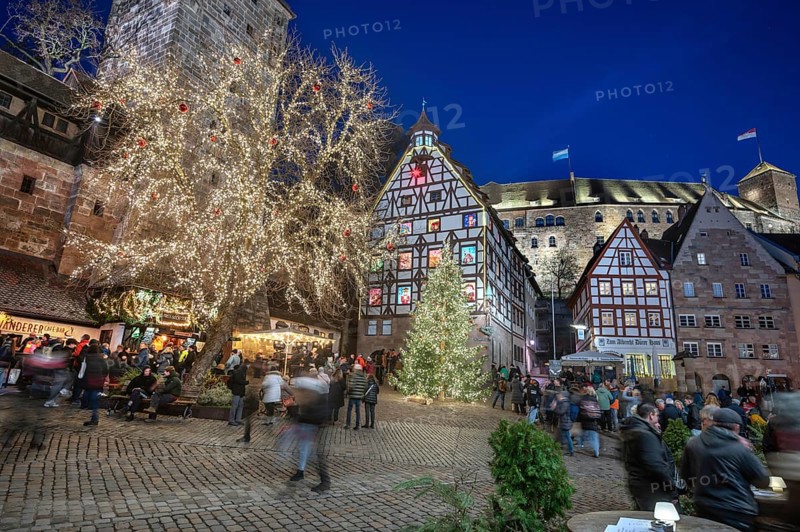 Illuminated trees with the historic Pilate House with advent calendar, in the evening lighting, the Kaiserburg in the back, Beim Tiergärtnertor, Nuremberg, Middle Franconia, Bavaria, Germany