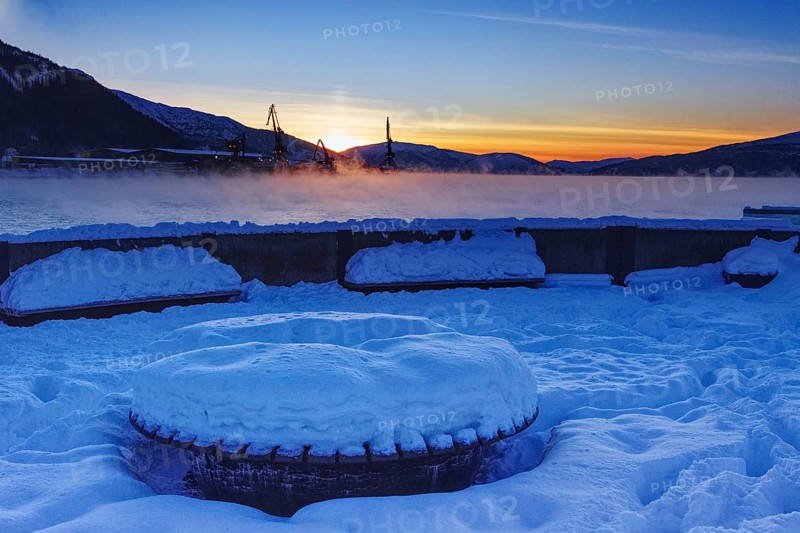 Snowy harbor at sunset, overlooking the water, Mo i Rana, Norway