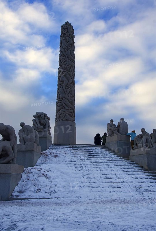 Large monolith surrounded by sculptures and a snowy staircase, Vigeland Sculpture Park Oslo Norway