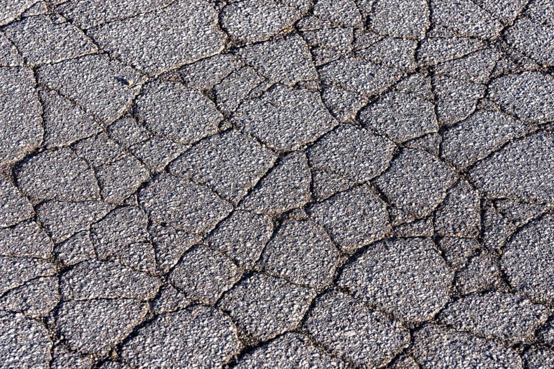 Asphalt surface, floor, with many small cracks, roadway, parking lot