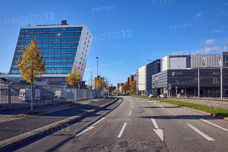 Schwedenkai ferry terminal, casino, general buildings, commercial buildings, modern architecture, lanes, central island, road markings direction arrow, lantern, cars, trees, autumn leaves, lawn, metal fence, blue sky, cumulus clouds, Kaistraße street, Kiel, state capital, district-free city, Schleswig-Holstein, Germany