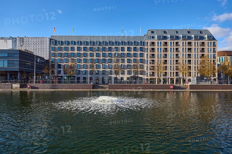 Boat harbor, water area, lake, ventilation pump, abstract reflections on the water surface, general architecture, building, modern architecture, hotel, Accor Group, ibis Styles, Adagio Access, façade with windows, trees, blue sky, cumulus clouds, Holstenbrücke street, Kiel, state capital, district-free city, Schleswig-Holstein, Germany