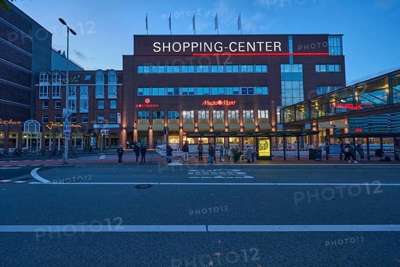 Sophienhof Kiel shopping center, commercial building, modern architecture, brick building, lantern, bus stop, bus lane, bus platform, waiting people and pedestrians as accessories, public transport, public transport, evening blue hour, blue evening sky, cumulus clouds, Sophienblatt street, Kiel, state capital, district-free city, Schleswig-Holstein, Germany